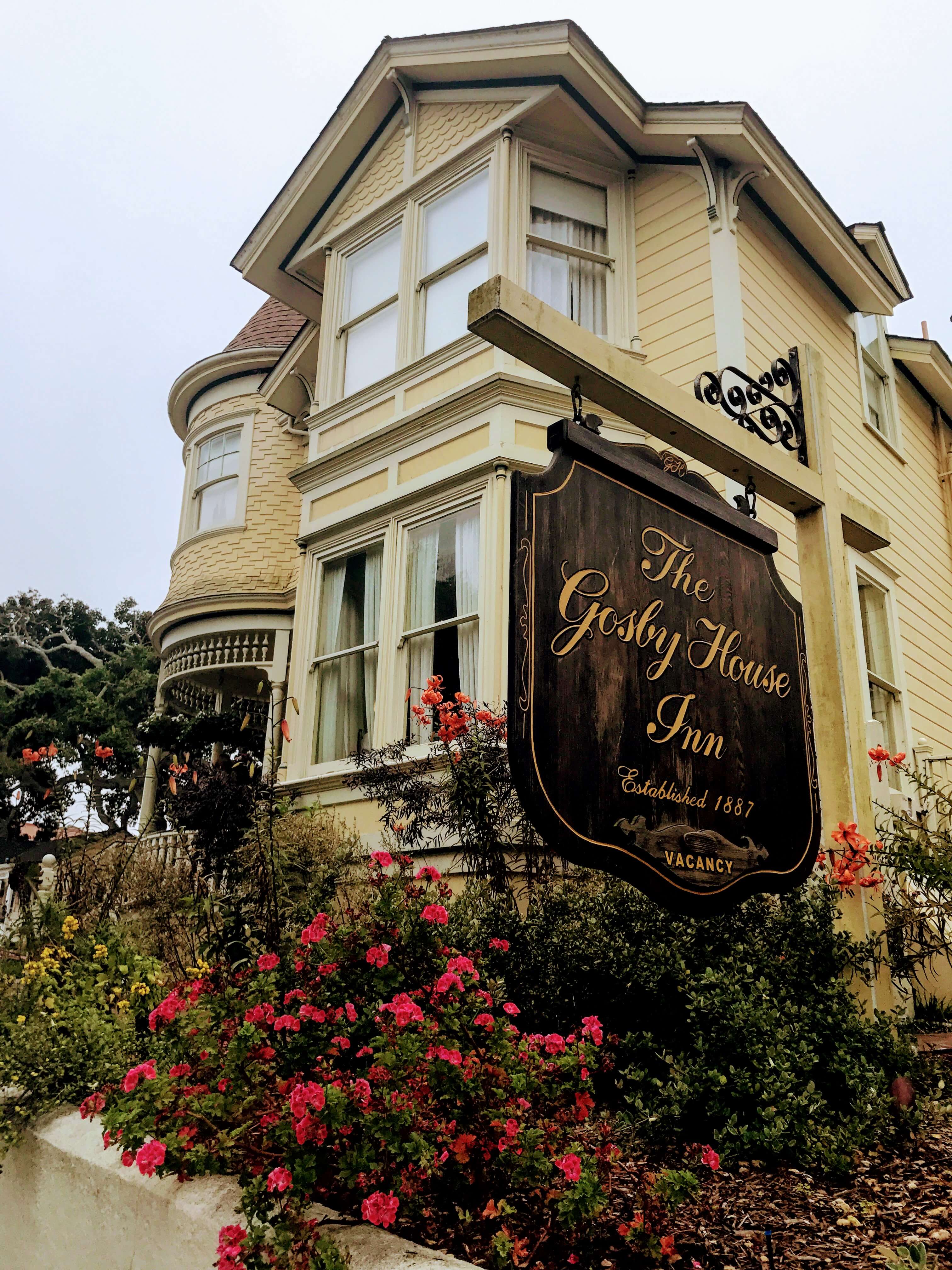 Sign out front of the Gosby House with beautiful flowers 