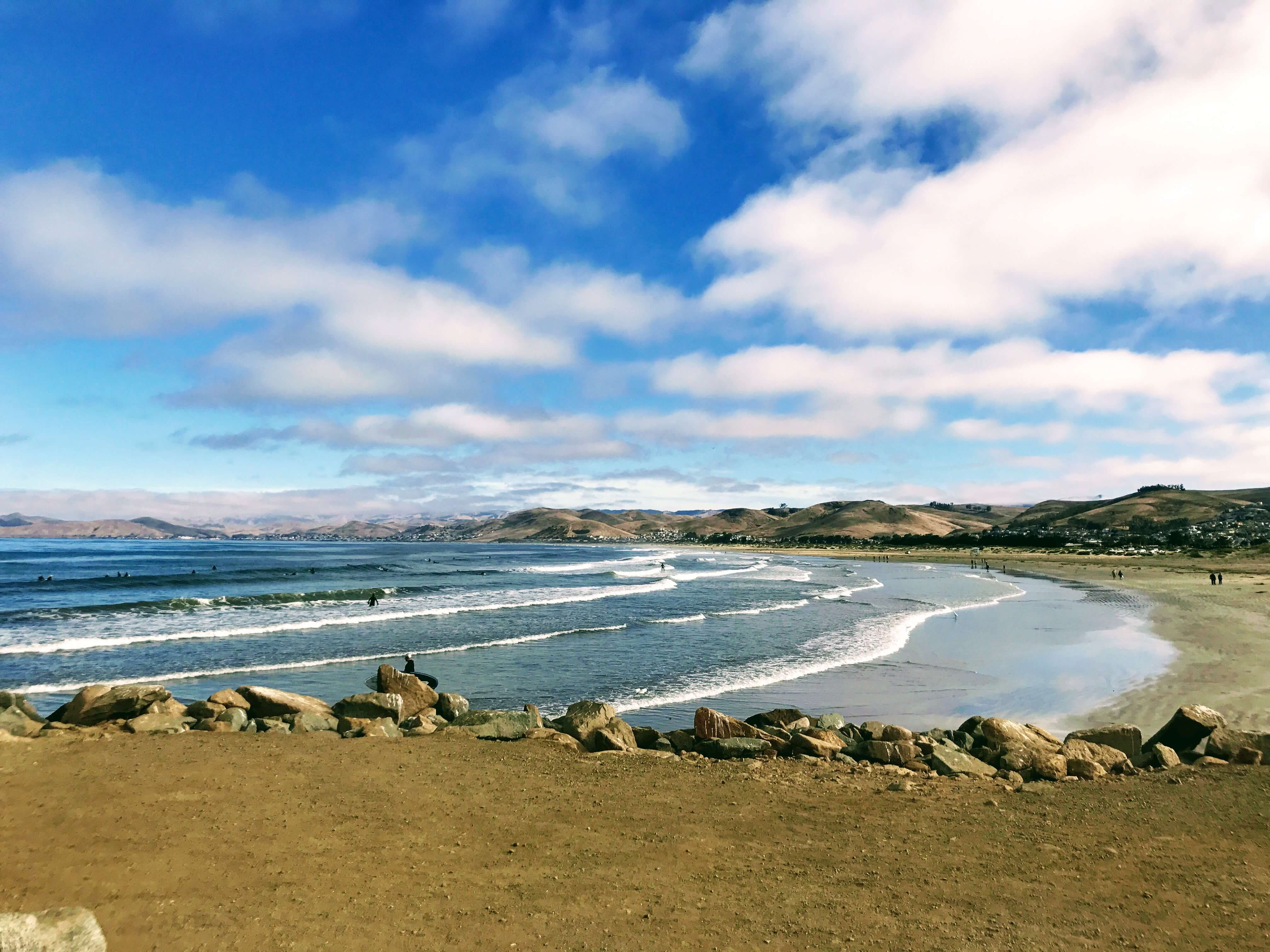 Surfers riding the waves in the beautiful beach along the California Coast