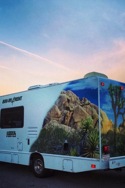 Cruise America RV on the road with sunset in the back ground and mountains