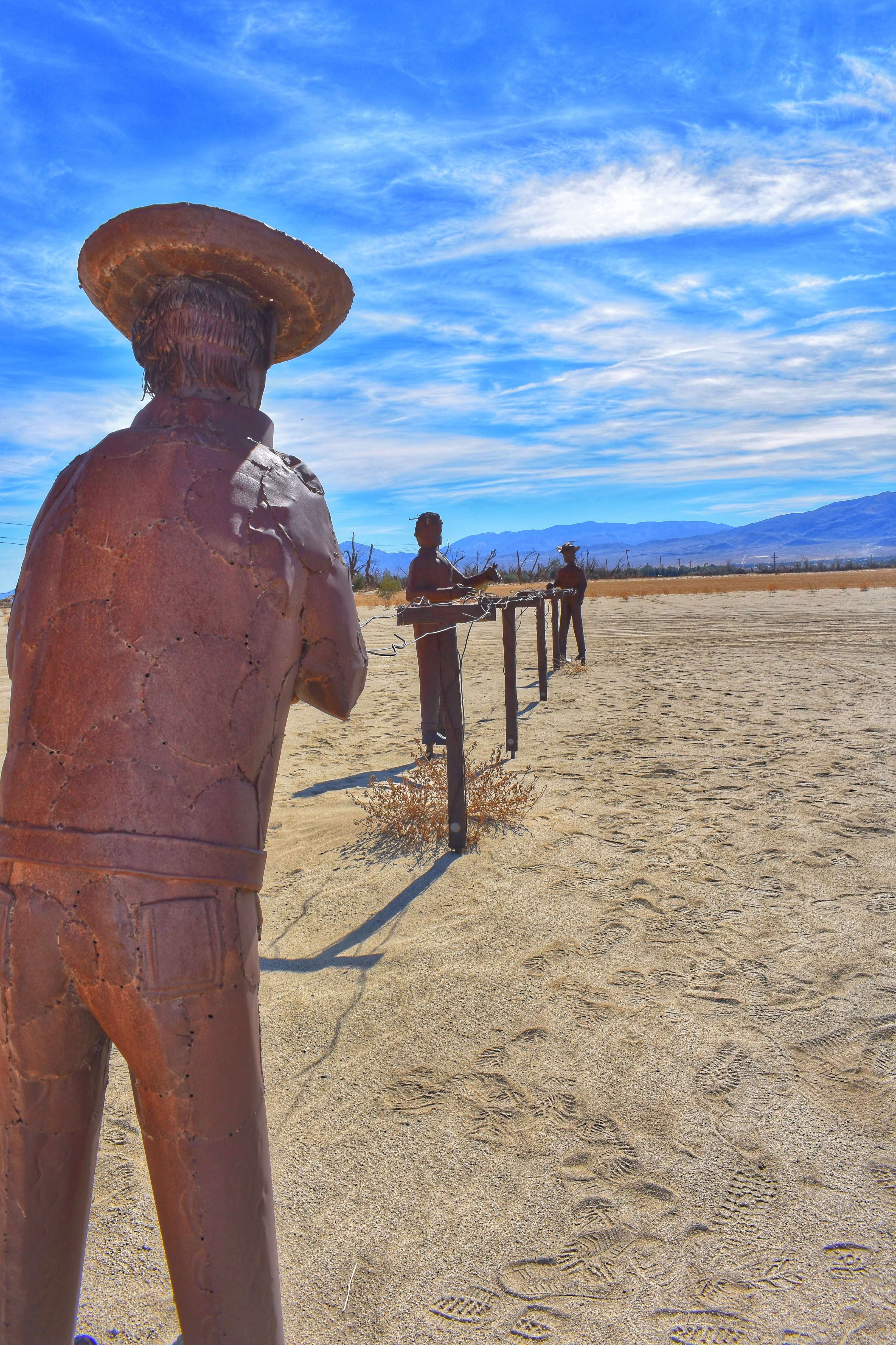 Sculpture of men building posts for wine growing