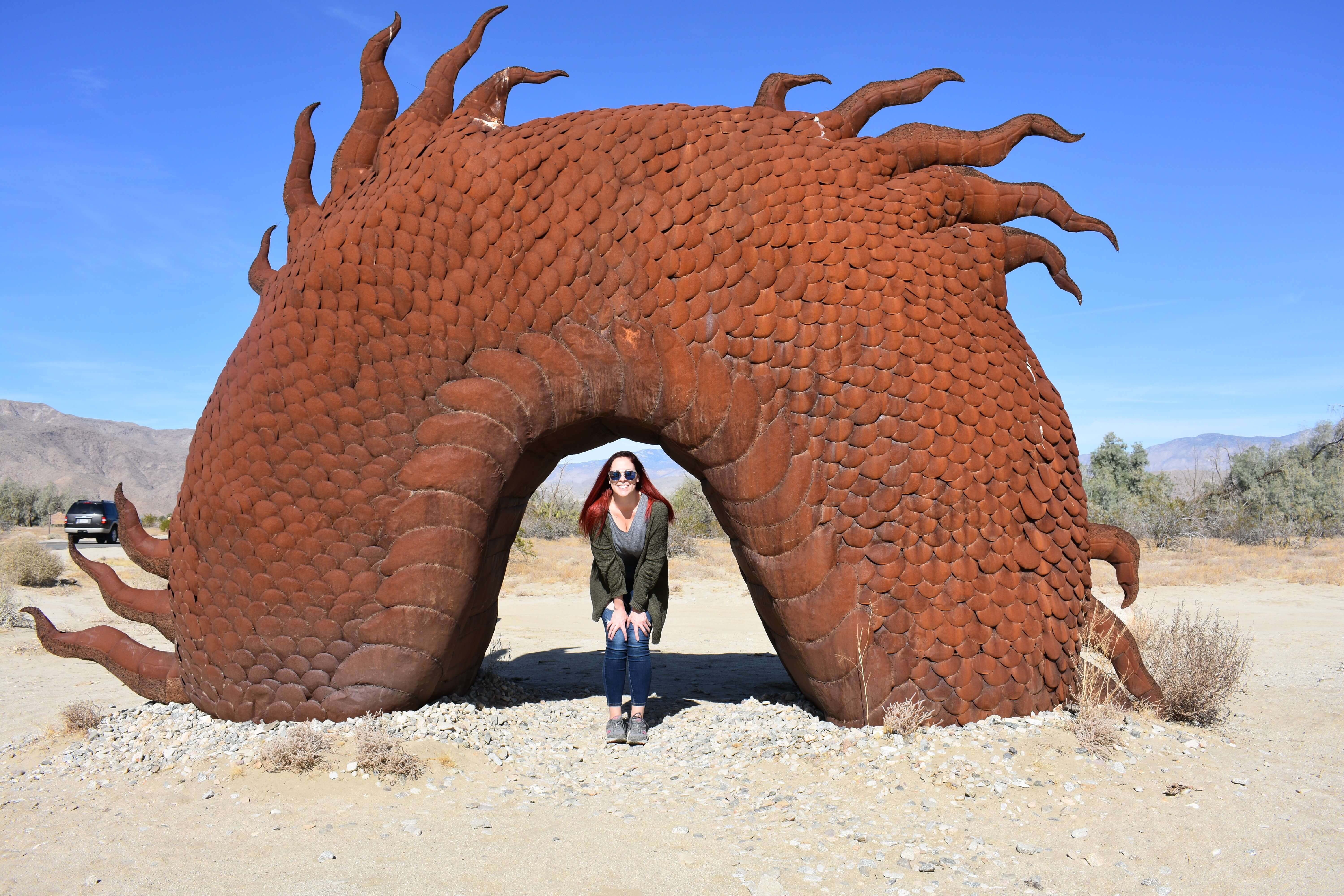 Girl underneath the hump of the dragon in the middle of the desert