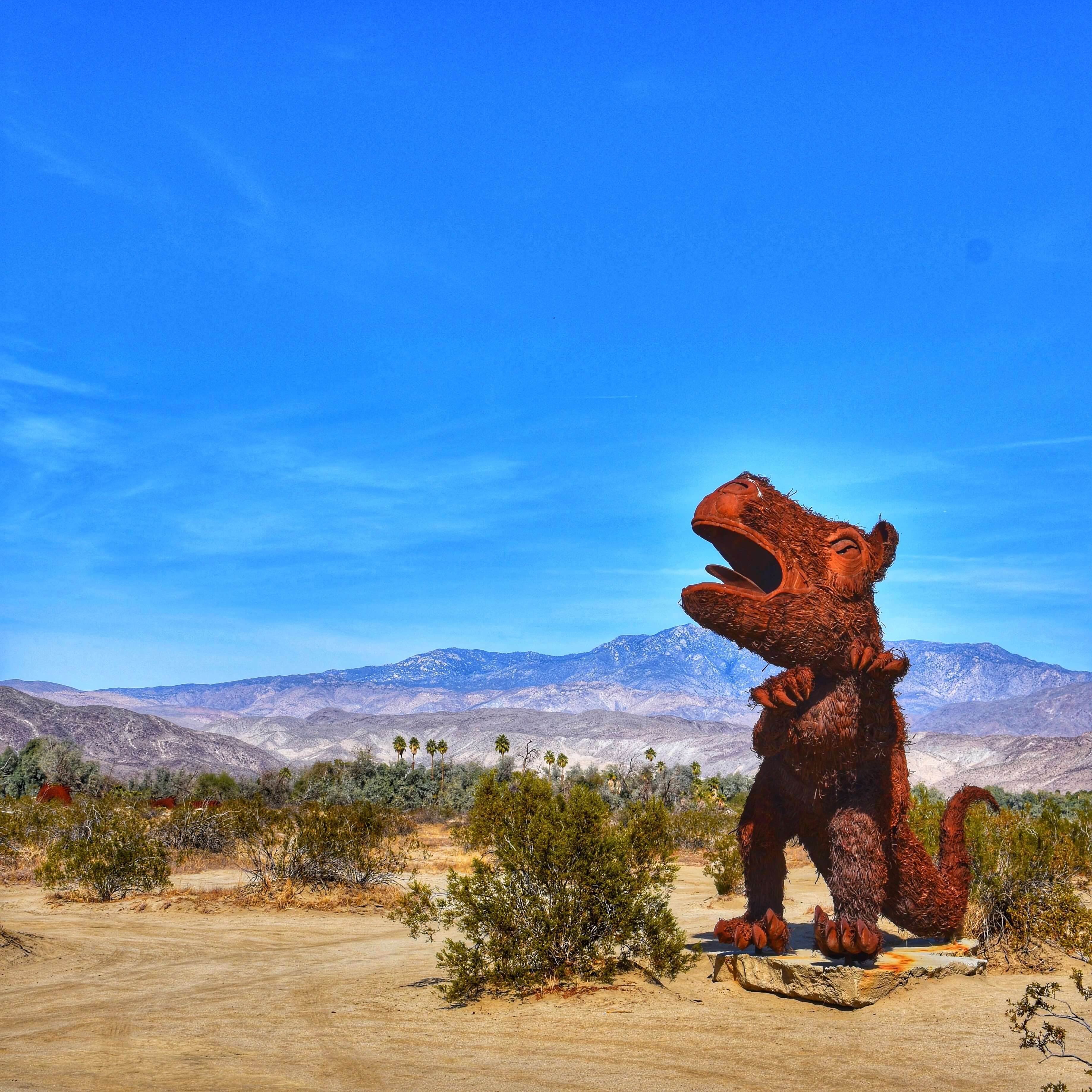 Dinosaur looking sculpture in the middle of the desert