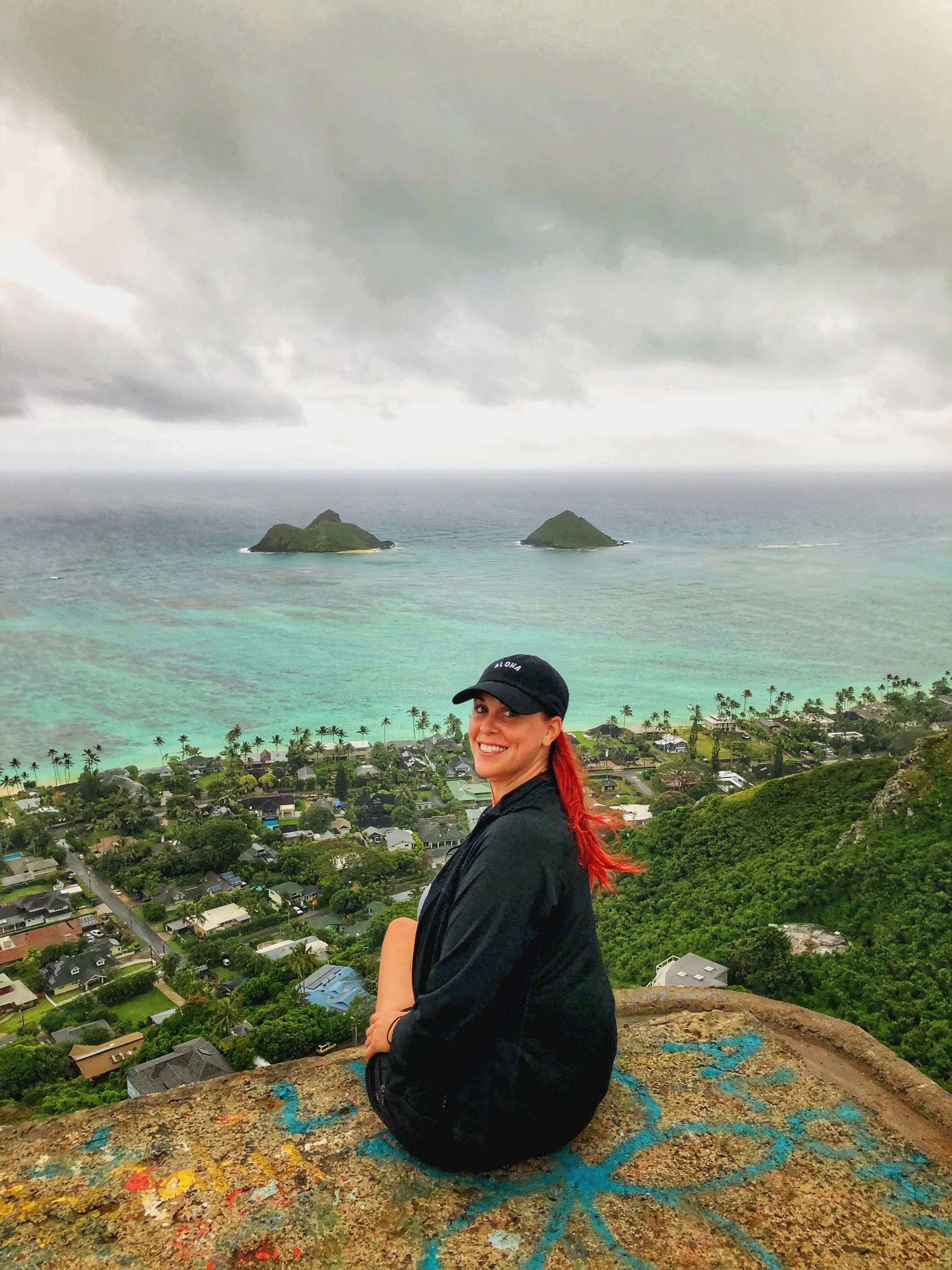 picture of me sitting on the pillbox atop lanikai pillbox hike overlooking turquoise waters