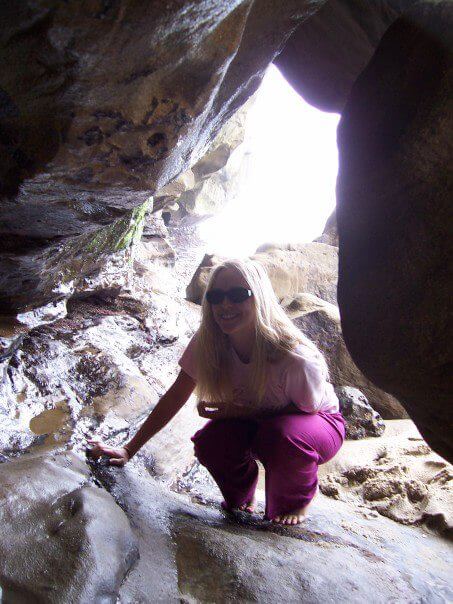 me crouching inside a cave on the beach in La Jolla 