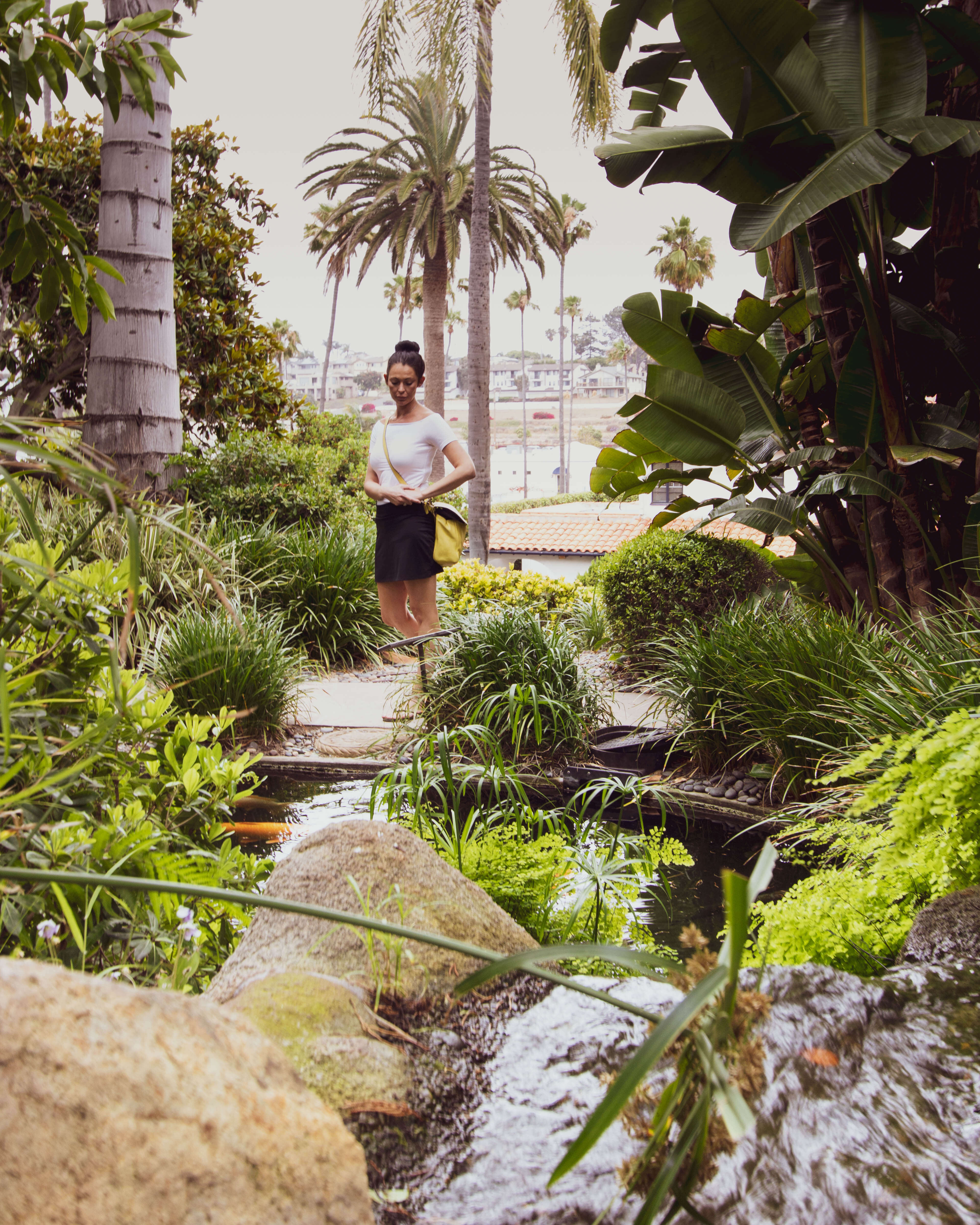 a girl reflecting next to the koi ponds in the meditation gardens