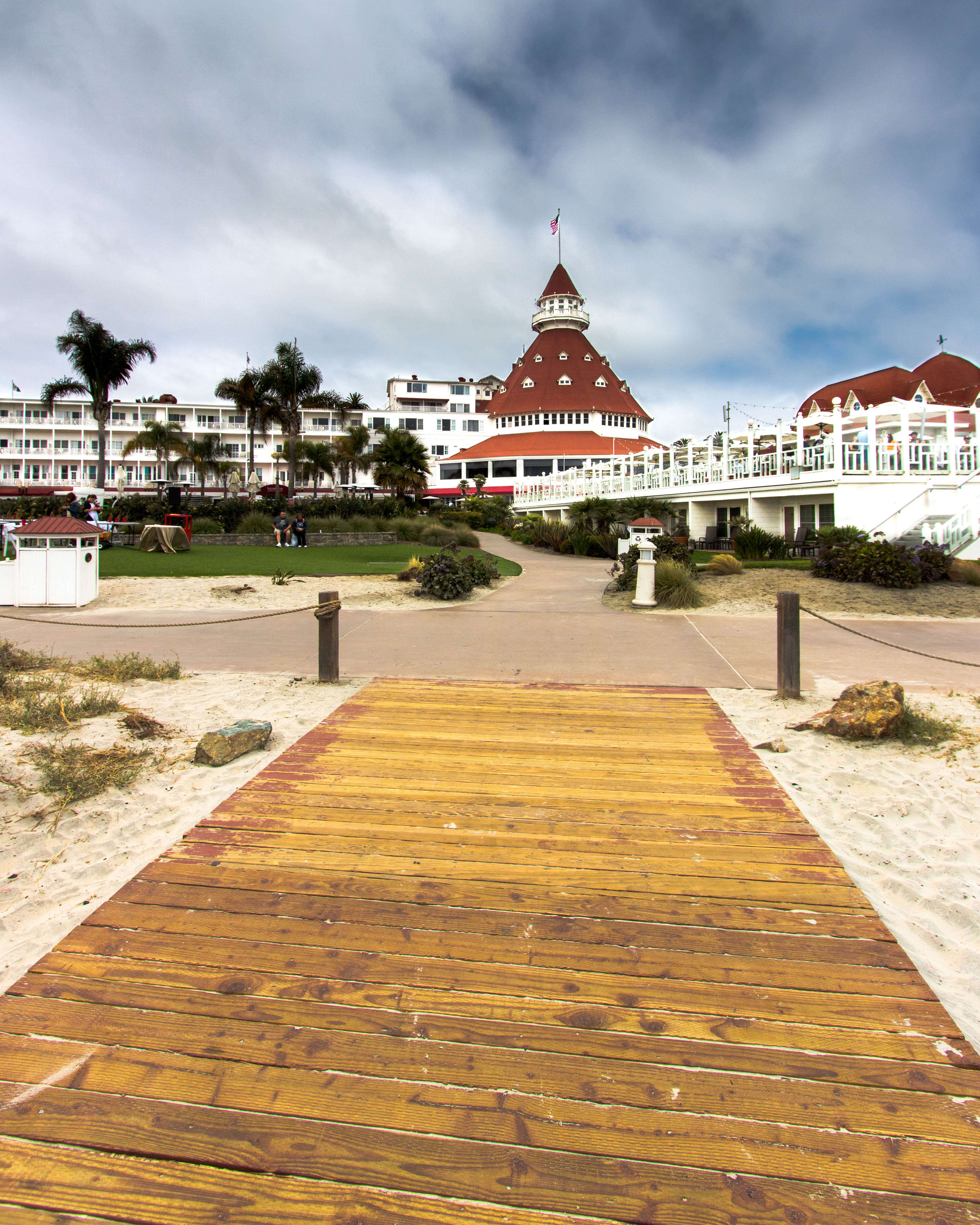 view of the iconic hotel del Coronado from the beach boardwalk, white hotel with red roof